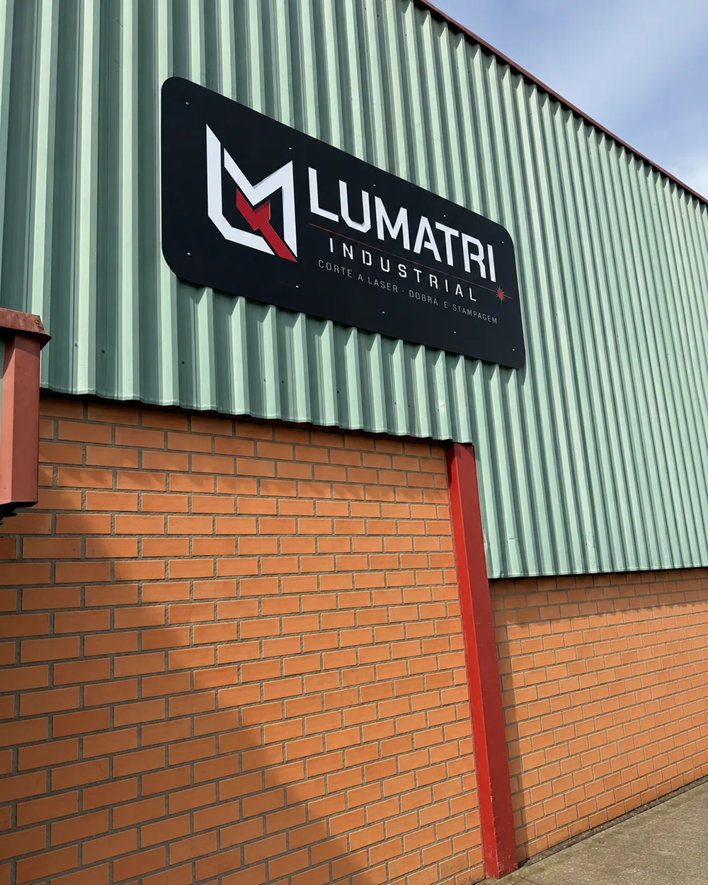 Fachada da Lumatri Industrial com a placa da empresa